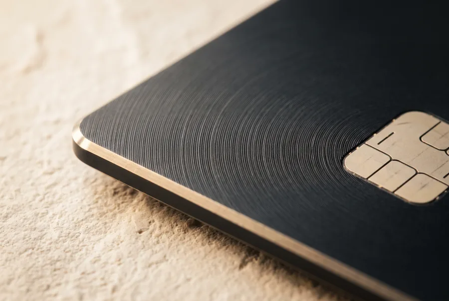 Macro detail of the card’s milled edge, concentric engraving and gold chip contacts.